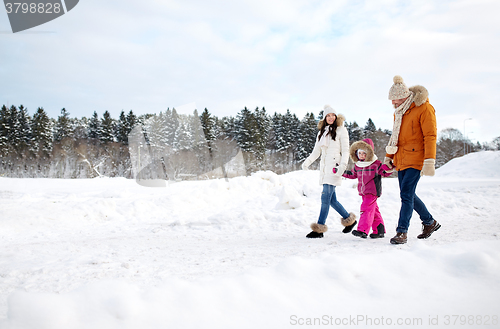 Image of happy family in winter clothes walking outdoors