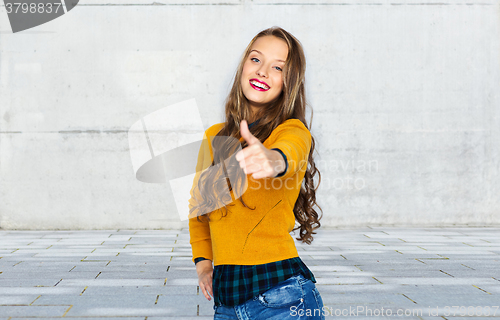 Image of happy young woman or teen girl showing thumbs up