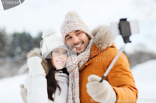 Image of happy couple taking selfie by smartphone in winter