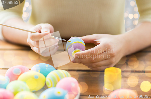 Image of close up of woman hands coloring easter eggs