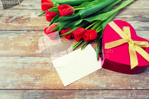 Image of close up of red tulips, letter and chocolate box