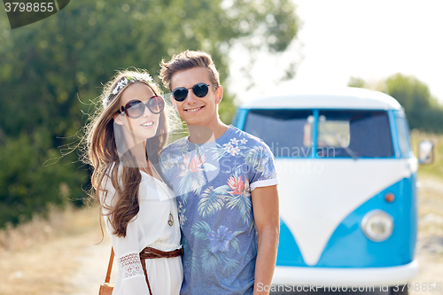 Image of smiling young hippie couple over minivan car