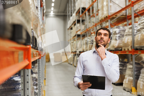 Image of businessman with clipboard at warehouse