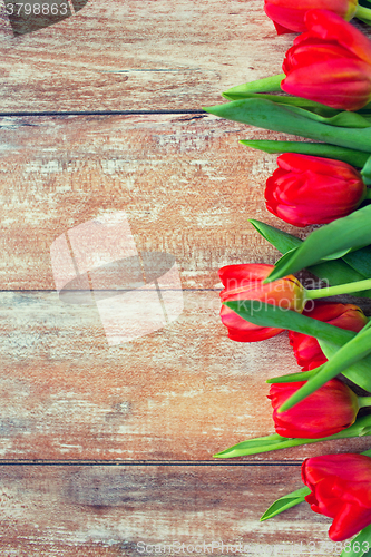 Image of close up of red tulips on wooden background