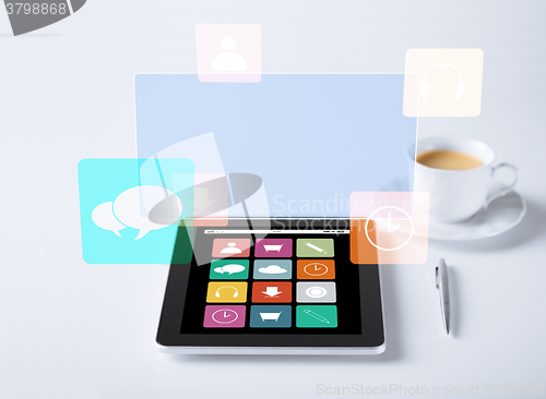 Image of tablet pc with application icons and cup of coffee