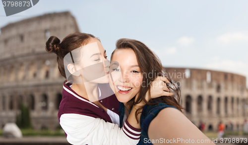 Image of happy teenage girls taking selfie over coliseum