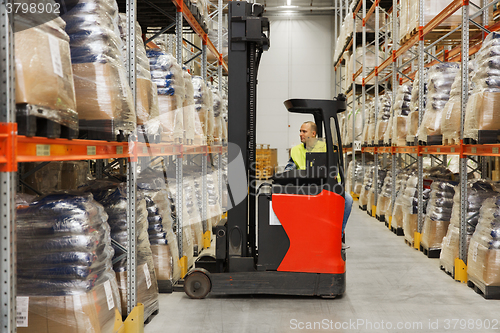 Image of man on forklift loading cargo at warehouse