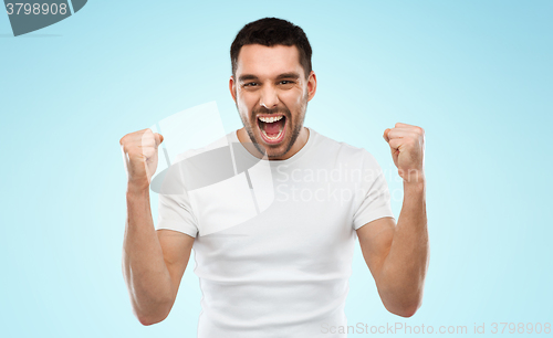 Image of young man celebrating victory blue gray