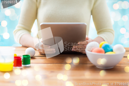 Image of close up of woman with tablet pc and easter eggs