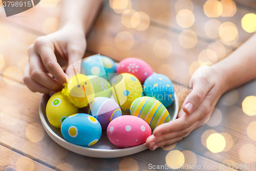 Image of close up of woman hands with colored easter eggs