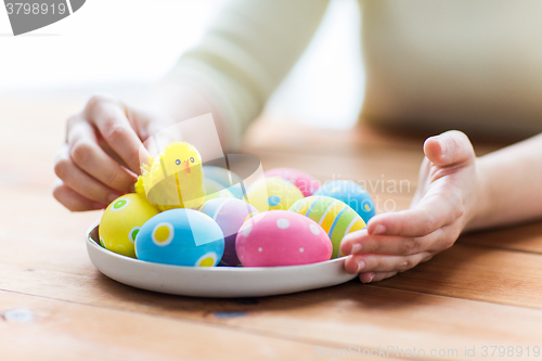 Image of close up of woman hands with colored easter eggs