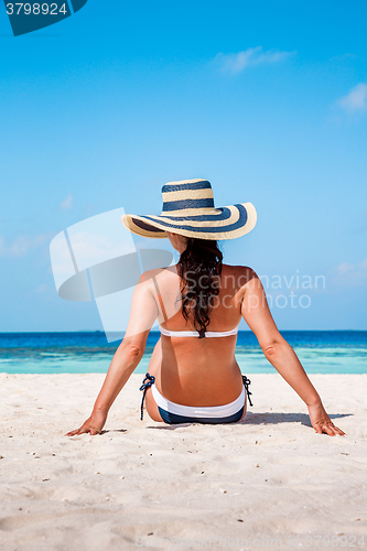 Image of Girl walking along a tropical beach in the Maldives.