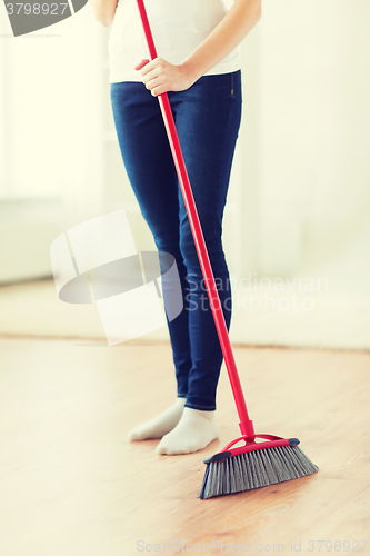 Image of close up of woman legs with broom sweeping floor