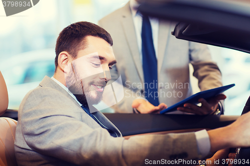 Image of happy man with car dealer in auto show or salon