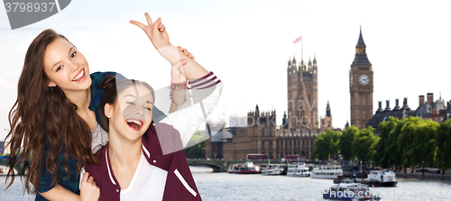 Image of happy teenage girls showing peace sign in london