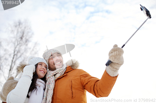 Image of happy couple taking selfie by smartphone in winter