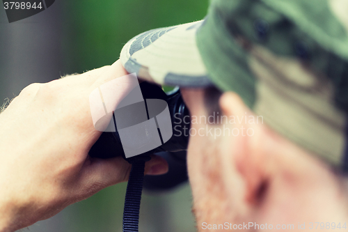 Image of close up of soldier or hunter with binocular