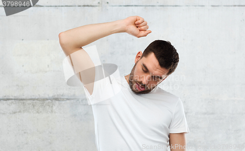 Image of young making gallows gesture over gray wall