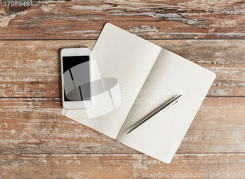 Image of close up of notebook, pen and smartphone