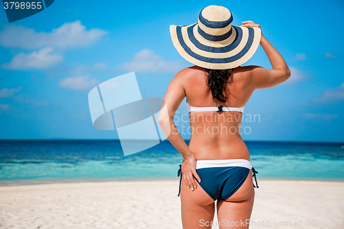 Image of Girl walking along a tropical beach in the Maldives.