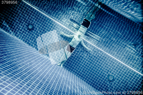 Image of Persons standing under water in a swimming pool