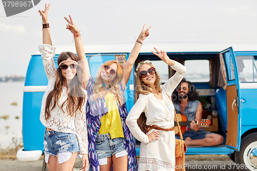 Image of happy hippie friends having fun over minivan car