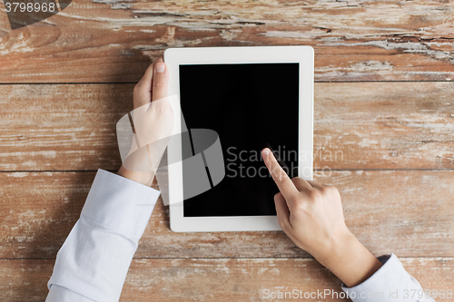Image of close up of female hands with tablet pc on table