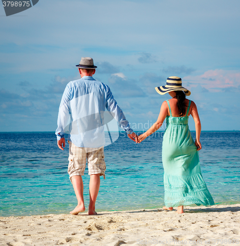 Image of Vacation Couple walking on tropical beach Maldives.