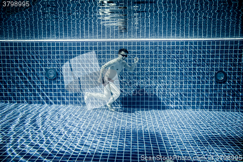 Image of Man runs underwater swimming pool