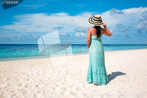 Image of Girl walking along a tropical beach in the Maldives.