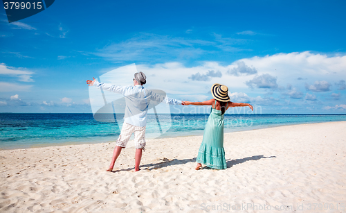 Image of Vacation Couple walking on tropical beach Maldives.