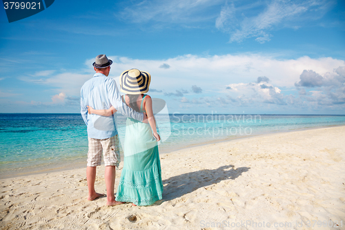 Image of Vacation Couple walking on tropical beach Maldives.