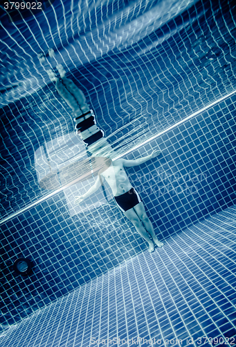 Image of Persons standing under water in a swimming pool