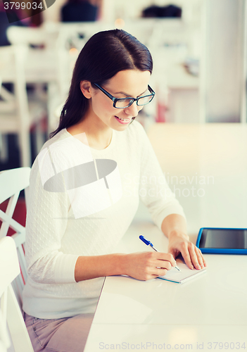 Image of smiling woman with tablet pc at cafe