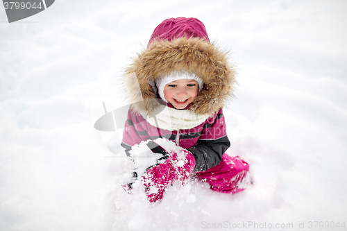 Image of f happy little child or girl with snow in winter