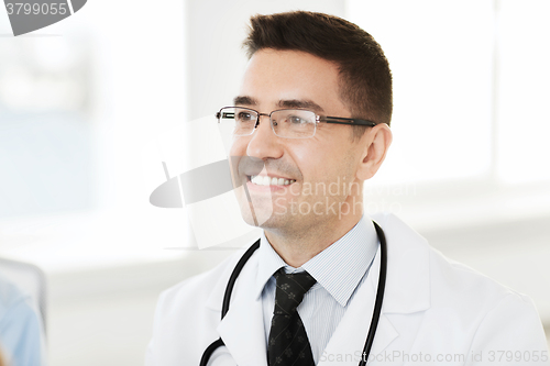 Image of smiling male doctor in white coat and eyeglasses
