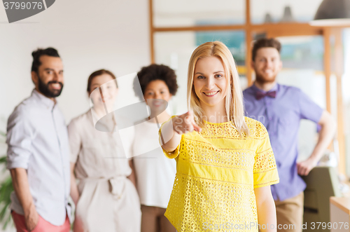 Image of woman pointing to you over creative office team