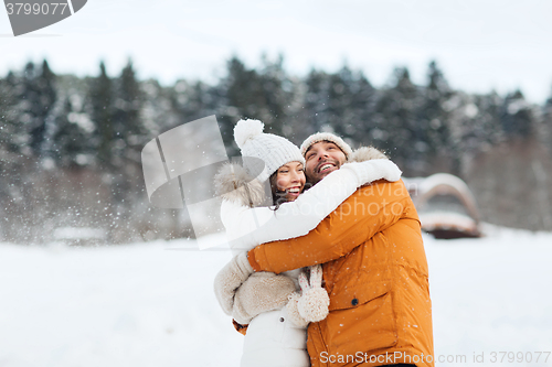 Image of happy couple hugging and laughing in winter