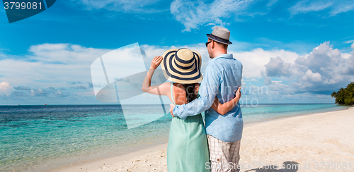 Image of Vacation Couple walking on tropical beach Maldives.