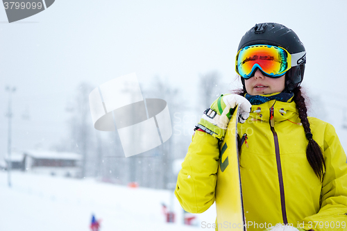 Image of Female snowboarder standing with snowboard