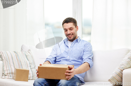 Image of happy man with cardboard boxes or parcels at home