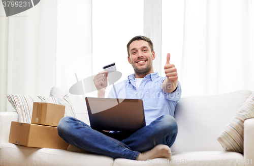 Image of man with laptop and credit card showing thumbs up