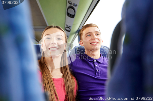 Image of happy teenage couple or passengers in travel bus