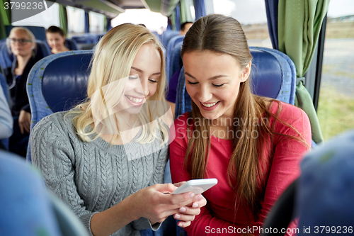 Image of happy young women in travel bus with smartphone