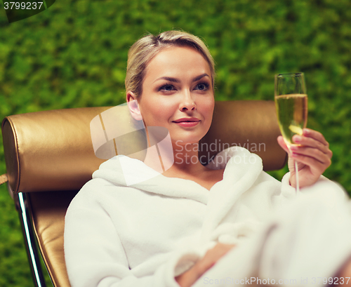 Image of beautiful young woman drinking champagne at spa