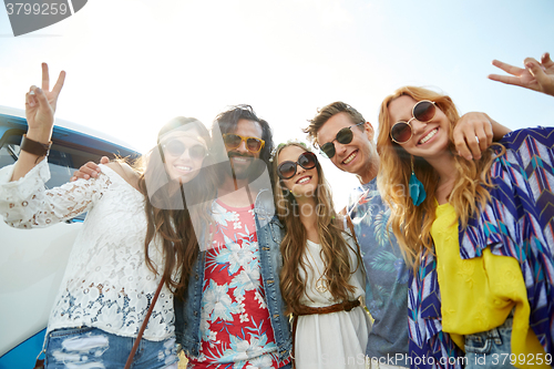 Image of hippie friends over minivan car showing peace sign