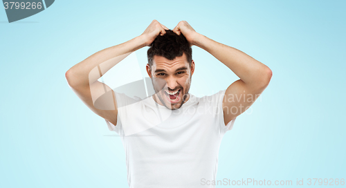 Image of crazy shouting man in t-shirt over blue background