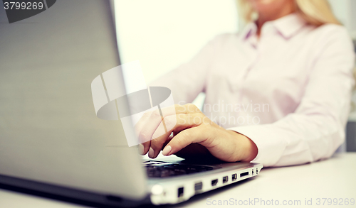 Image of smiling businesswoman or student typing on laptop