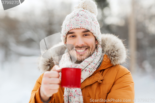 Image of happy man with tea cup outdoors in winter