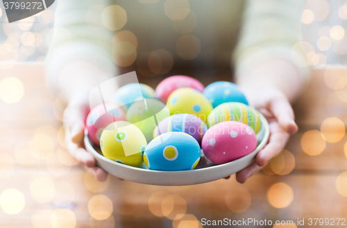 Image of close up of woman hands with colored easter eggs